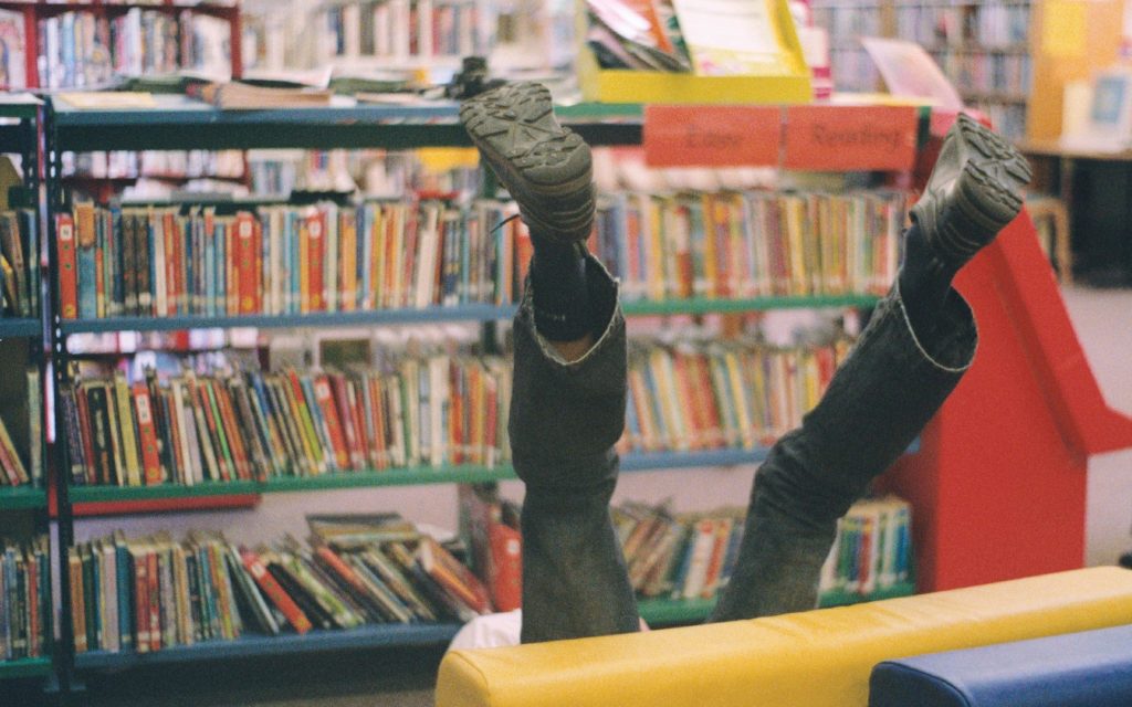 A photo of legs sticking up into the air from behind a children